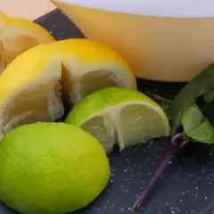 Kawałki cytryny i limonki, świeża mięta i miska. Idealne składniki na orzeźwiający napój.