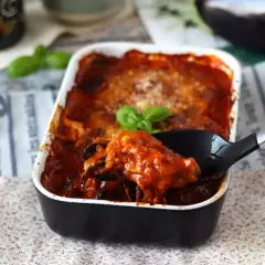 Pyszne, oryginalne parmigiana z bakłażana w sosie pomidorowym, prosto z naczynia żaroodpornego.