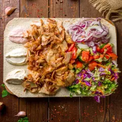 Pyszna baranina w kebabie z warzywami i sosami na desce.