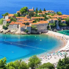 Sveti Stefan, Czarnogóra: jakie morze? Turkusowe wody Adriatyku otaczają wyspę z kamiennymi domkami i piaszczystą plażą pełną turystów.