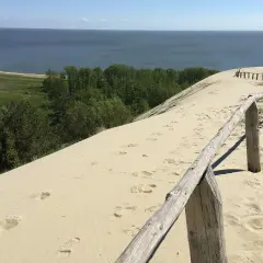 Piaskowe wydmy nad Bałtykiem, gdzie ślady stóp prowadzą do morza. Ciekawe, ile km ma morze bałtyckie, by dotrzeć do horyzontu?