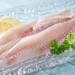Filety łupacza, delikatna ryba, gotowa do przygotowania z cytryną i natką pietruszki.
