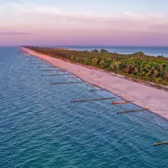 Zachód słońca nad Bałtykiem, gdzie widać piaszczystą plażę i las, tworzące najwęższe miejsce na Helu.