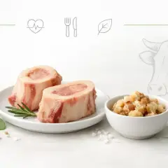 Dwa kawałki wołowego szpiku na talerzu, obok miseczka z chrupiącymi skwarkami. Odkryj niezwykłe szpik wołowy właściwości.