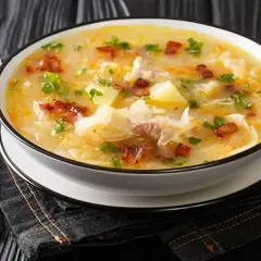 Gęsta zupa z kapusty kiszonej, ziemniaków i boczku, posypana natką pietruszki. Idealna na zimowe wieczory, smakuje jak u babci, prawdziwy pazibroda!
