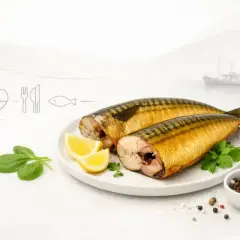 Dwie wędzone makrele na talerzu z cytryną i szpinakiem. Czy makrela wędzona jest zdrowa? Tak, to bogactwo kwasów omega-3.