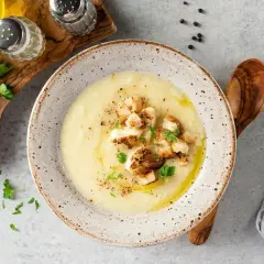 Aksamitna zupa krem z kiszonej kapusty, udekorowana chrupiącymi grzankami i świeżą natką pietruszki. Idealna na chłodne dni.