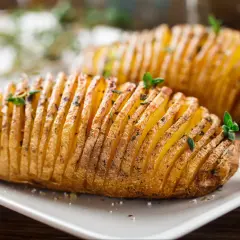 Ziemniaki hasselback, które Ania gotuje, wyglądają apetycznie. Delikatnie nacięte i upieczone, z ziołami na wierzchu.