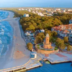 Widok na wybrzeże Bałtyku z plażą, molo, latarnią morską i miastem. To piękne wyspy na Bałtyku, gdzie można podziwiać architekturę i morze.