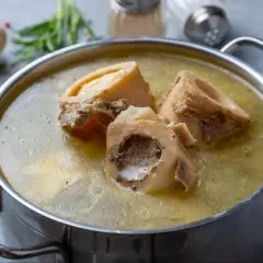 Aromatyczny bulion kolagenowy przepis w garnku, z kośćmi wołowymi i warzywami w tle. Idealny na zdrowie!