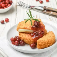 Chrupiący ser w panierce z żurawiną i rozmarynem, podany na talerzu. Idealna przekąska na zimowe wieczory.