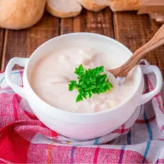 Kremowa zupa z kaczką, doprawiona aromatycznym tłuszczem z kaczki, podana z natką pietruszki i pieczywem.
