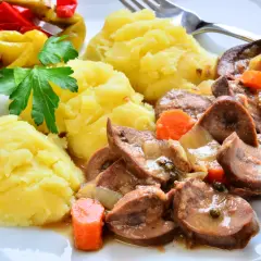 Cynaderki duszone z marchewką i cebulą, podane z puree ziemniaczanym i pikantnymi papryczkami. Pyszne danie, które warto spróbować!