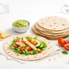 Czy tortilla jest zdrowa? Na talerzu pełnym świeżych warzyw, kurczaka i guacamole, stosik tortilli czeka na przygotowanie.