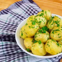 Pyszne, młode ziemniaki posypane koperkiem i szczypiorkiem. Idealne, gdy zastanawiasz się, ile się gotuje ziemniaki.