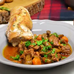 Wołowina po burgundzku, danie z duszonym mięsem, grzybami i marchewką, podane z bagietką. Oryginalny przepis na wyśmienite danie.