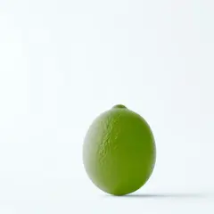 Jedna soczysta limonka czy limetka, idealna do drinków i potraw, na jasnym tle.