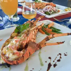 Wykwintne mauritius jedzenie: grillowany homar z warzywami i drinkami. Pyszny posiłek na wakacjach.