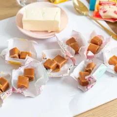 Szybkie domowe krówki, gotowe do schrupania! Obok masło, jajko i opakowanie z przepisem.