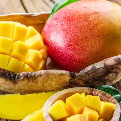 Soczysty mango owoc, pokrojony w kostkę i w całości, prezentuje swoje bogactwo witamin.