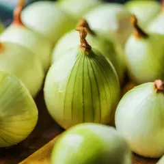 Grupka świeżych, obranych cebul. Czy cebula jest ciężkostrawna? Zależy od sposobu przygotowania, ale te wyglądają apetycznie.