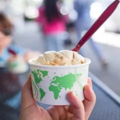 Kubek z lodami na tle rozmazanego dziecka. Czy można jeść rozmrożone lody? Tak, jeśli zostały ponownie zamrożone.