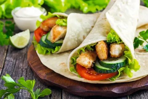 Dwa pyszne wrapy z kurczakiem, warzywami i sosem. To właśnie jest tortilla – idealna na szybki posiłek.