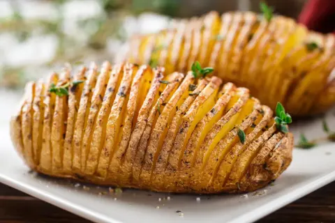 Ziemniaki hasselback, które Ania gotuje, wyglądają apetycznie. Delikatnie nacięte i upieczone, z ziołami na wierzchu.
