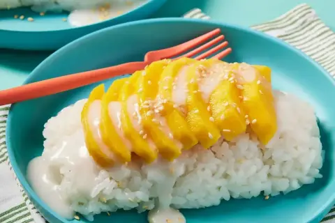 Pyszny deser mango sticky rice przepis. Kleisty ryż z kawałkami mango, polany mlekiem kokosowym i posypany sezamem.