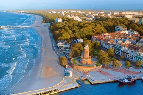 Widok na wybrzeże Bałtyku z plażą, molo, latarnią morską i miastem. To piękne wyspy na Bałtyku, gdzie można podziwiać architekturę i morze.