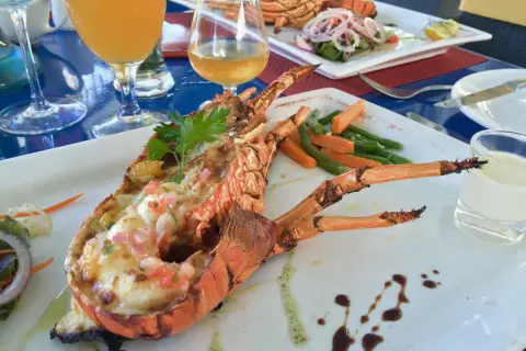 Wykwintne mauritius jedzenie: grillowany homar z warzywami i drinkami. Pyszny posiłek na wakacjach.