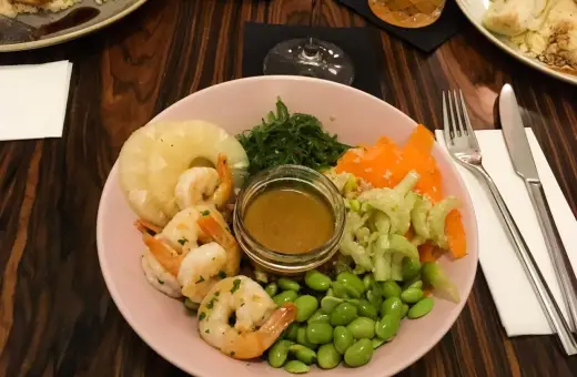 Kraków co zjeść? Kolorowa miska z krewetkami, ananasem, edamame i sosem. Idealna na lekki posiłek.