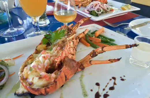 Wykwintne mauritius jedzenie: grillowany homar z warzywami i drinkami. Pyszny posiłek na wakacjach.