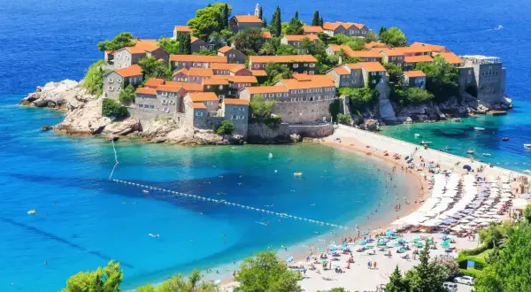 Sveti Stefan, Czarnogóra: jakie morze? Turkusowe wody Adriatyku otaczają wyspę z kamiennymi domkami i piaszczystą plażą pełną turystów.