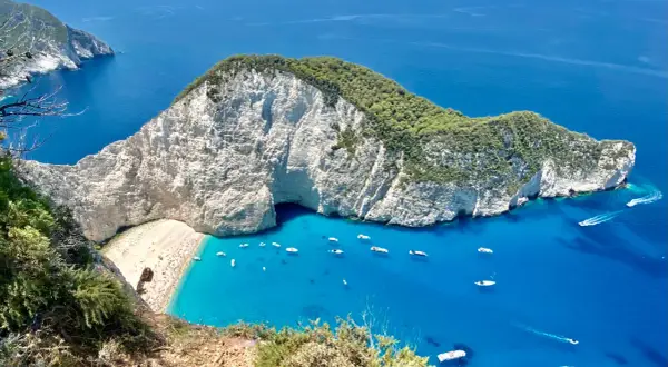 Zakynthos: jakie morze? Turkusowe wody otaczają białe klify i plażę Navagio, pełną łodzi i turystów.
