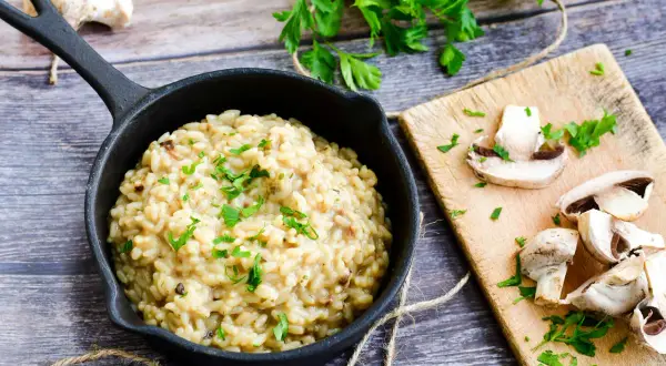 Kremowe risotto z grzybami, posypane natką pietruszki. Idealny risotto przepis podstawowy na pyszny obiad.
