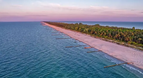 Zachód słońca nad Bałtykiem, gdzie widać piaszczystą plażę i las, tworzące najwęższe miejsce na Helu.