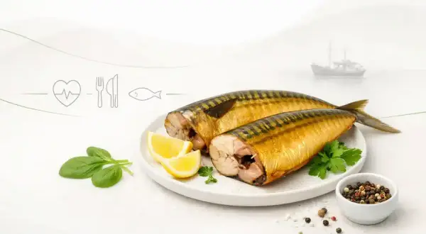 Dwie wędzone makrele na talerzu z cytryną i szpinakiem. Czy makrela wędzona jest zdrowa? Tak, to bogactwo kwasów omega-3.
