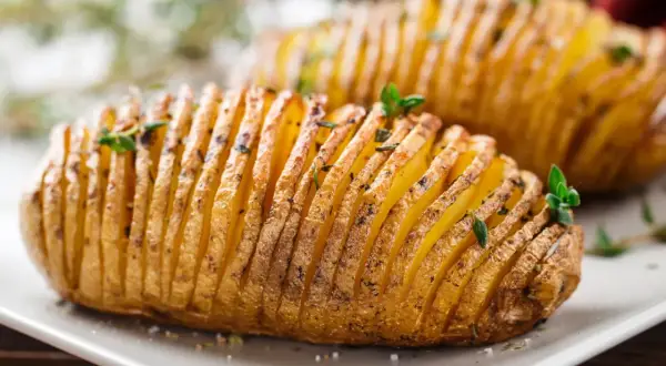 Ziemniaki hasselback, które Ania gotuje, wyglądają apetycznie. Delikatnie nacięte i upieczone, z ziołami na wierzchu.