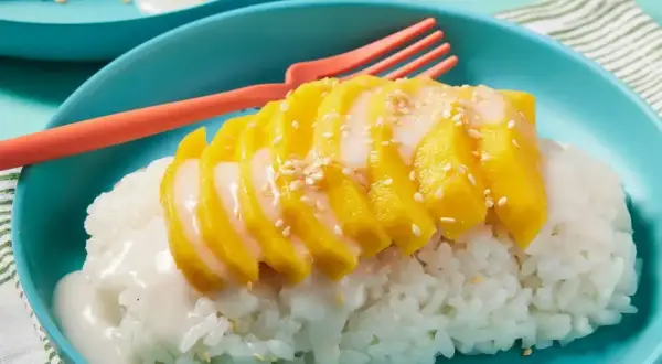 Pyszny deser mango sticky rice przepis. Kleisty ryż z kawałkami mango, polany mlekiem kokosowym i posypany sezamem.