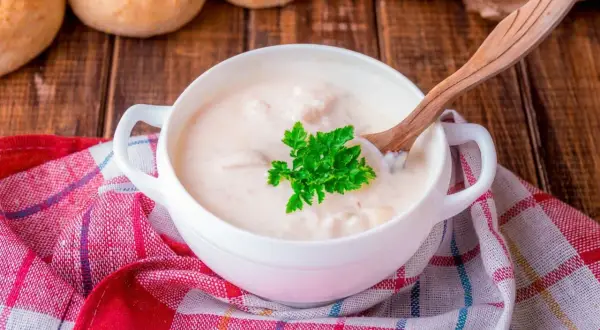 Kremowa zupa z kaczką, doprawiona aromatycznym tłuszczem z kaczki, podana z natką pietruszki i pieczywem.