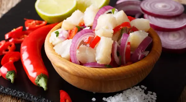 Pyszne ceviche co to? Świeża ryba, chili, czerwona cebula i limonka w drewnianej misce.
