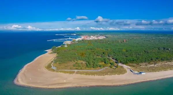Widok z lotu ptaka na Półwysep Helski, gdzie leży Jastarnia. Piękna plaża, las i port w oddali.