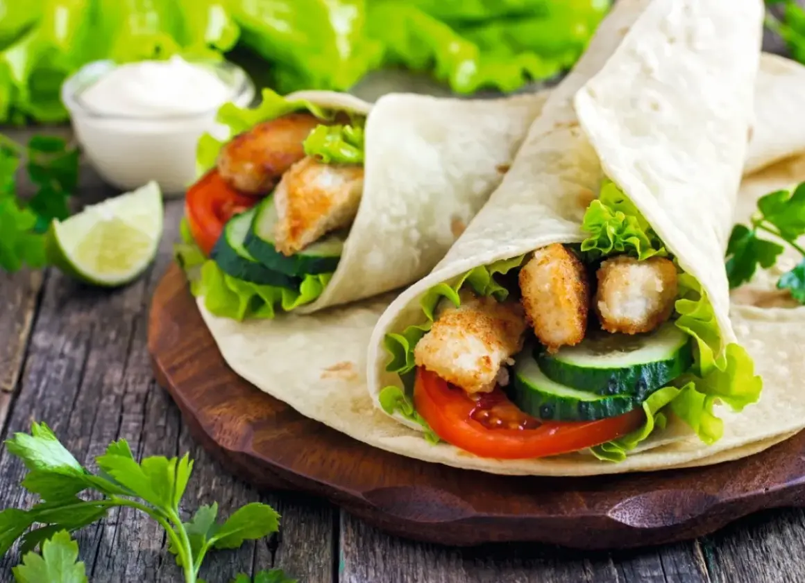 Dwa pyszne wrapy z kurczakiem, warzywami i sosem. To właśnie jest tortilla – idealna na szybki posiłek.