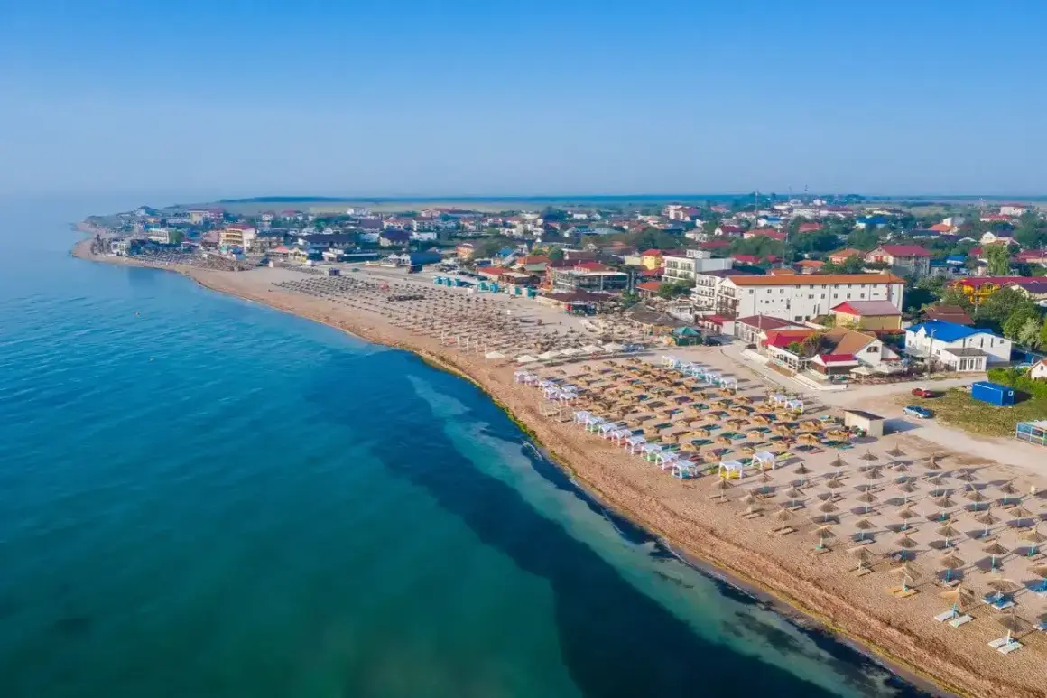 Widok na plażę z rzędami leżaków i parasoli. W tle zabudowania kurortowe. Woda w morzu czarnym jest ciepła, idealna do kąpieli.