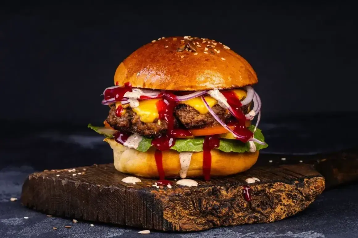 Pyszny, soczysty burger z serem, cebulą i sosem. Idealny na prawdziwe burgery przepis.