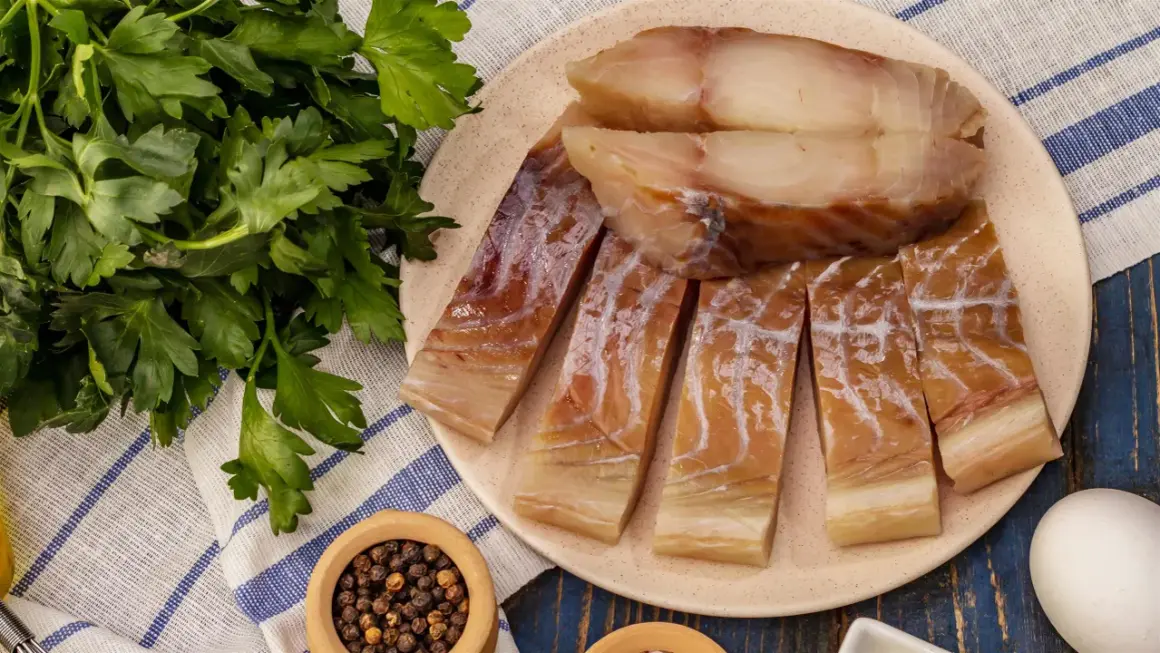 Pokrojona w plastry ryba czerniak, gotowa do podania z natką pietruszki i pieprzem.