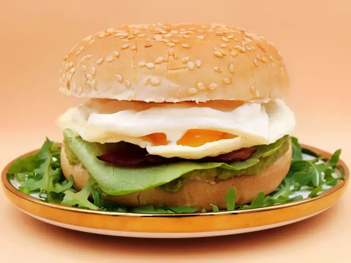 Pyszny burger z jajkiem sadzonym, awokado i rukolą. Idealny pomysł na to, co do burgera.