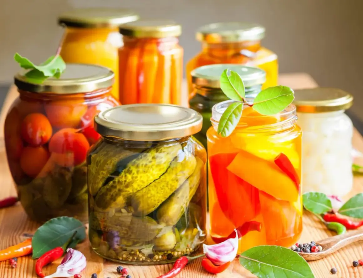 Słoiki z przetworami: ogórki, pomidory, papryka, marchewka. Pasteryzacja zapewnia ich trwałość.