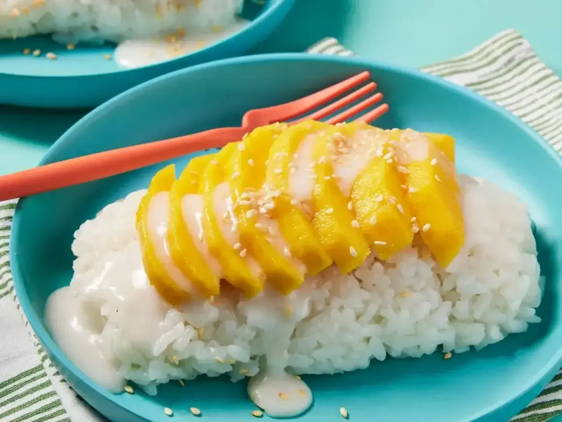 Pyszny deser mango sticky rice przepis. Kleisty ryż z kawałkami mango, polany mlekiem kokosowym i posypany sezamem.